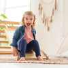 A young girl is smiling ear to ear while sliding down the 2-in-1 Climbing Ramp / Slide.