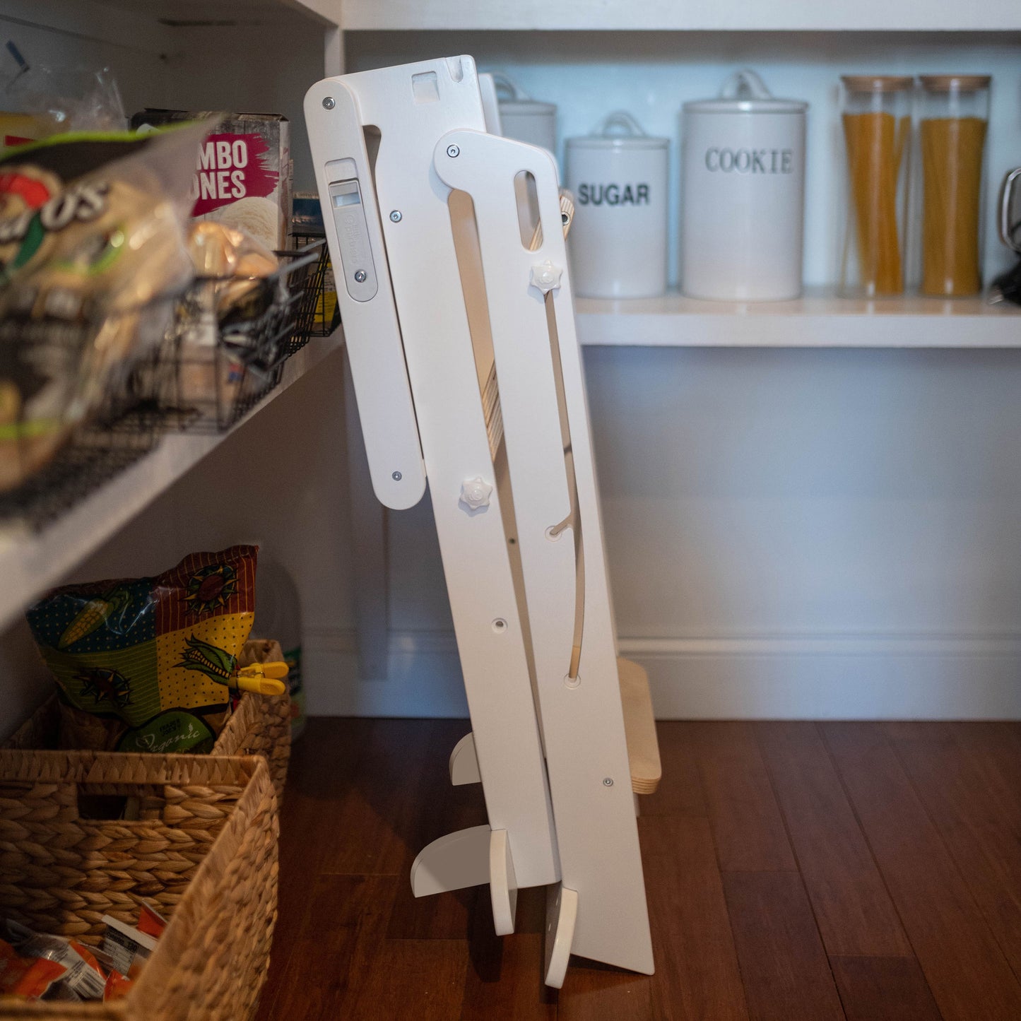 The Learn N Fold Learning Tower is folded up and stored in a kitchen pantry.