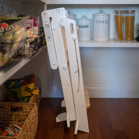 The Learn N Fold Learning Tower is folded up and stored in a kitchen pantry.