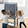 A young girl and boy are drawing on the Artist EZ Easel.