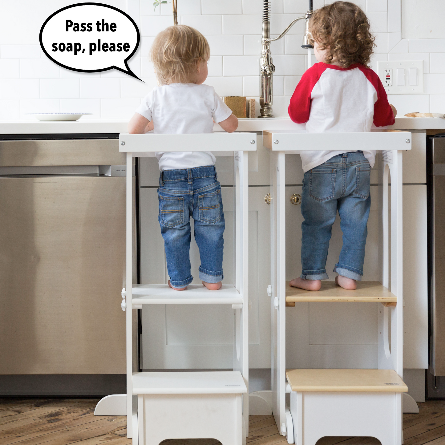 Two children stand at the kitchen sink in Explore N Store Learning Towers.  One child says "Pass the soap" to the other.