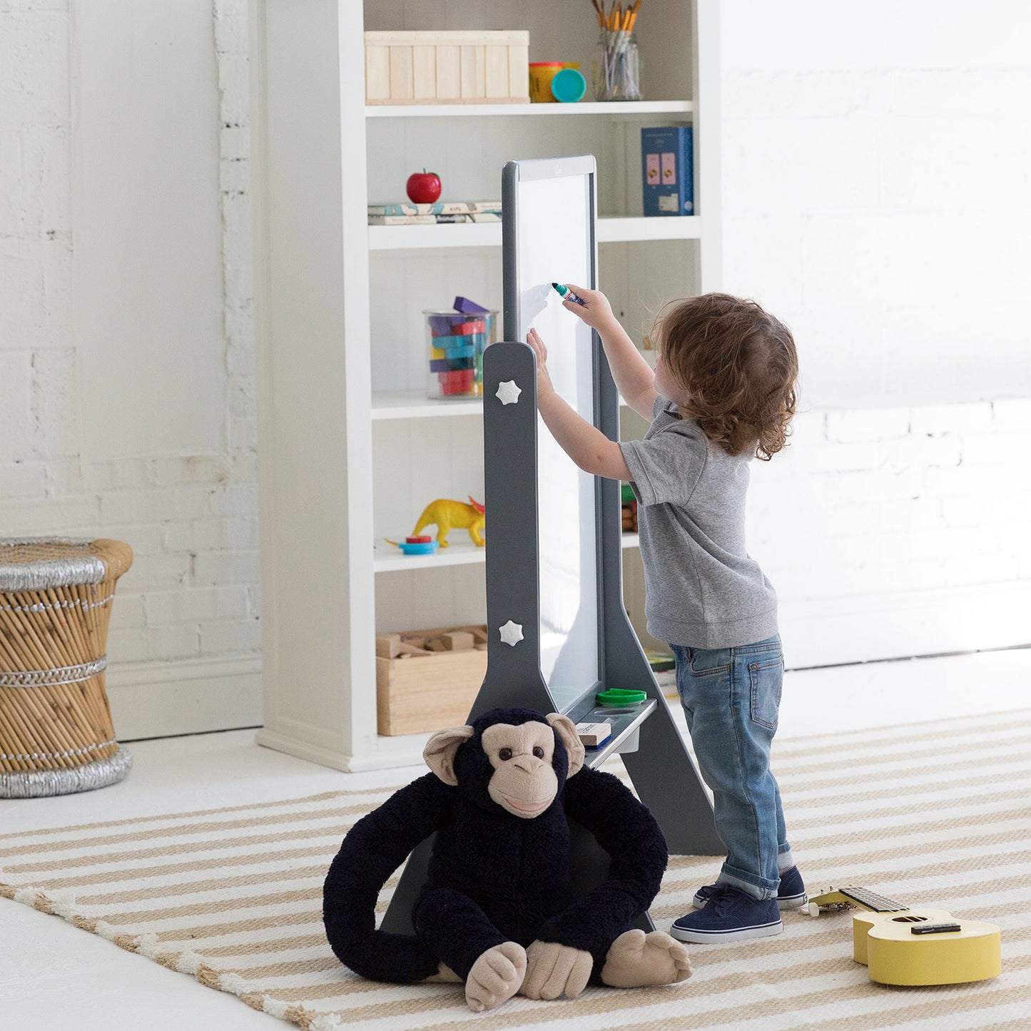 A young boy is coloring with markers on the Contempo Art Easel.