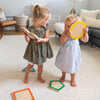 Two girls are holding Shape Stepping Stones in their hand.